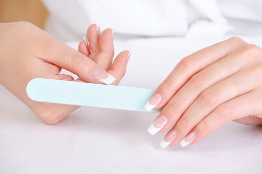 femme se limant les ongles après sa manucure au polygel 