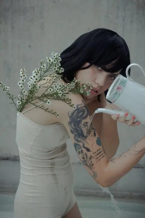 A tattooed woman using tattoo anaesthetic cream