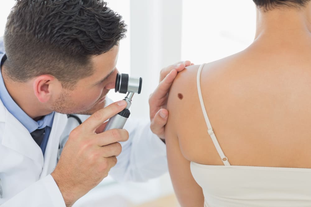 dermatologist examining a woman with skin disease 