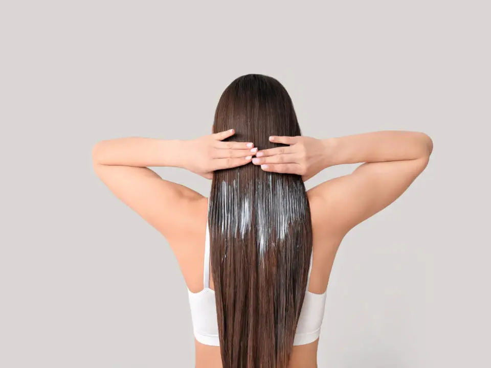 Sérum cheveux : Femme de dos avec sérum dans les cheveux