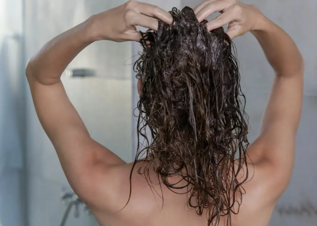 Sérum cheveux : Femme qui se nettoie les cheveux après usage d'un sérum